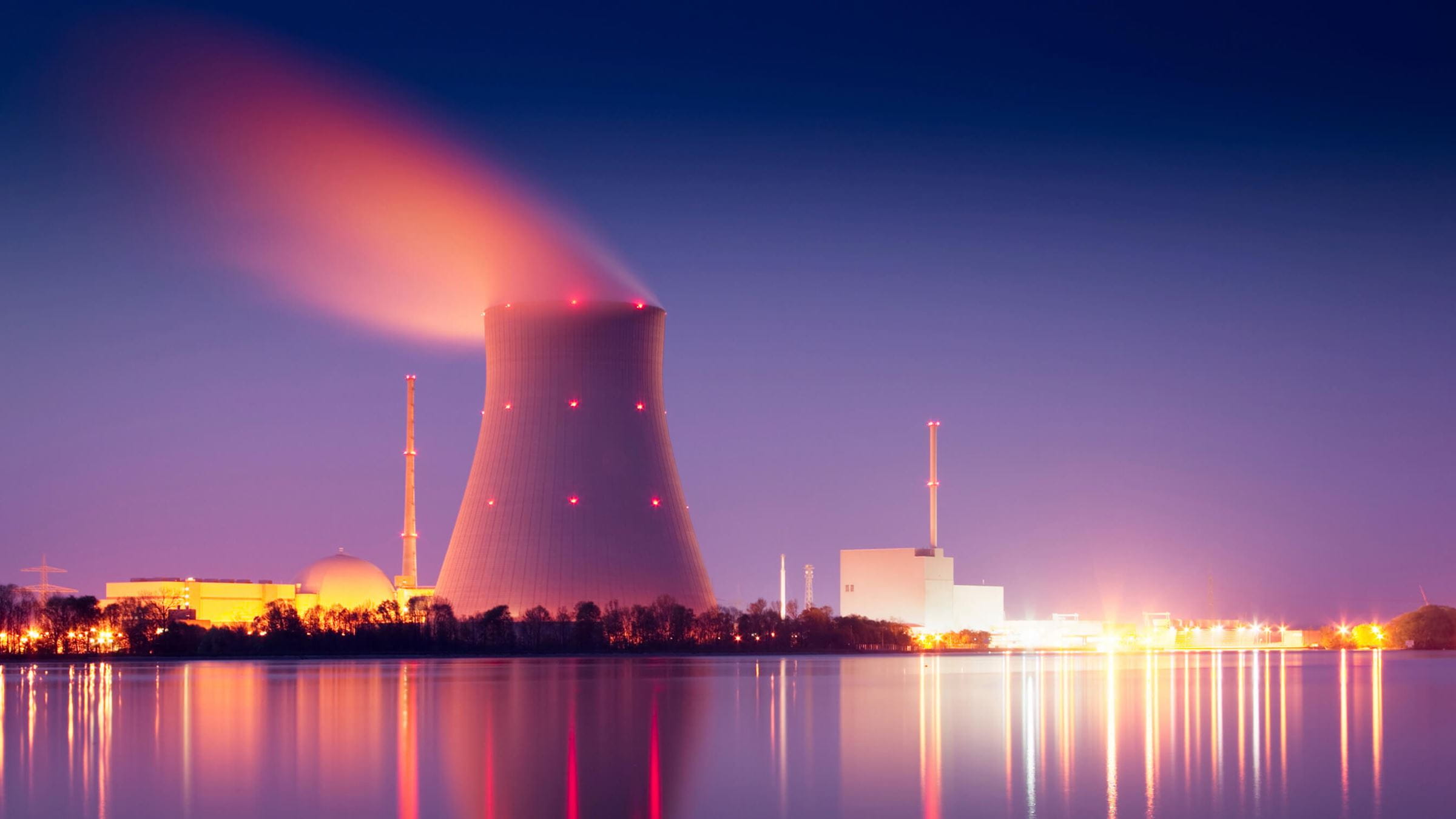 View across water to a nuclear power plant at night