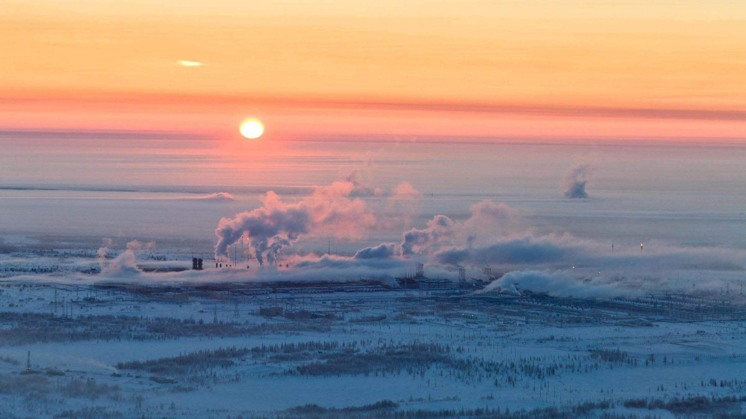 日落时冰封冻原上的炼油厂