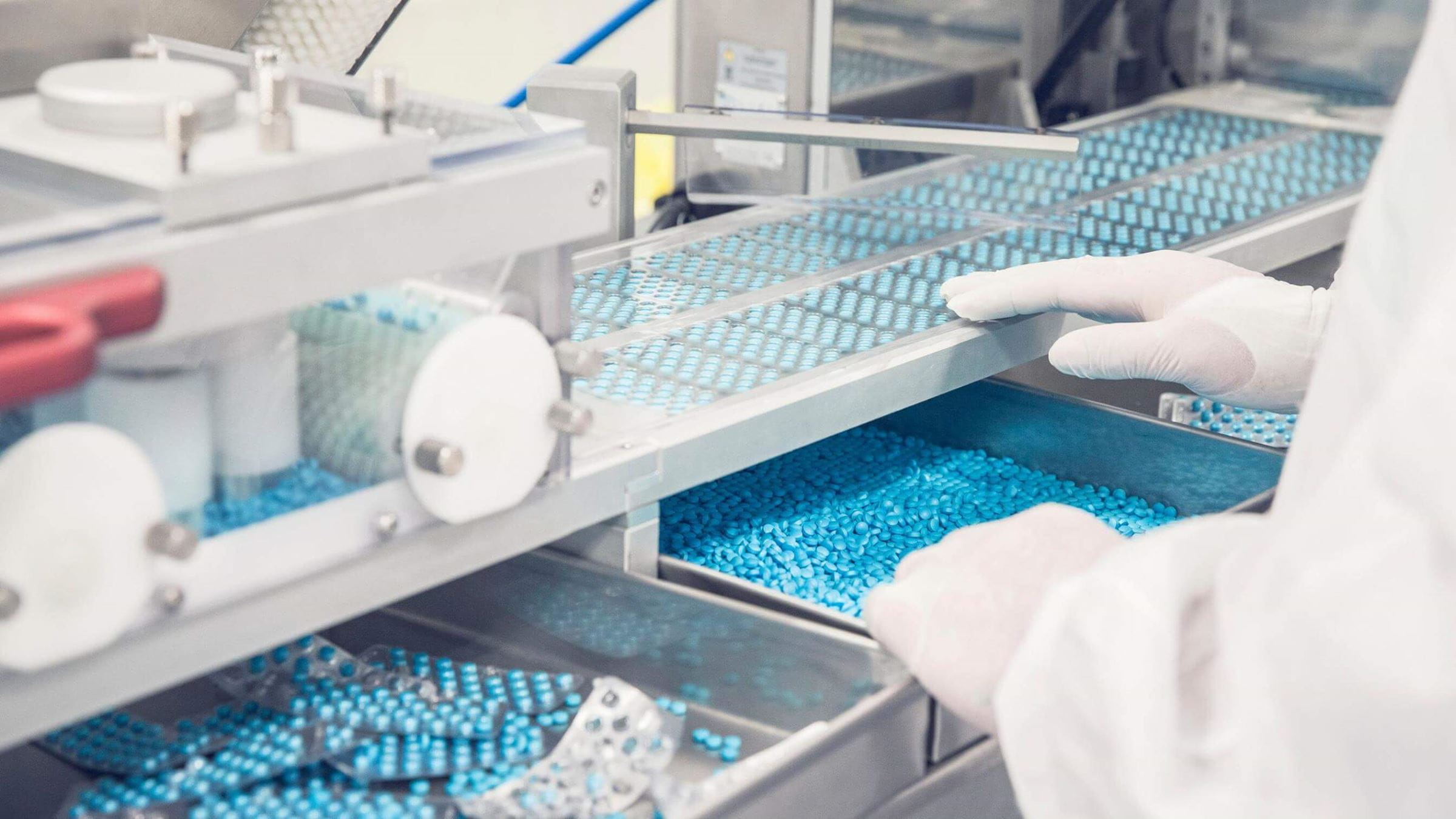 Technician sorting pharmaceutical tablets