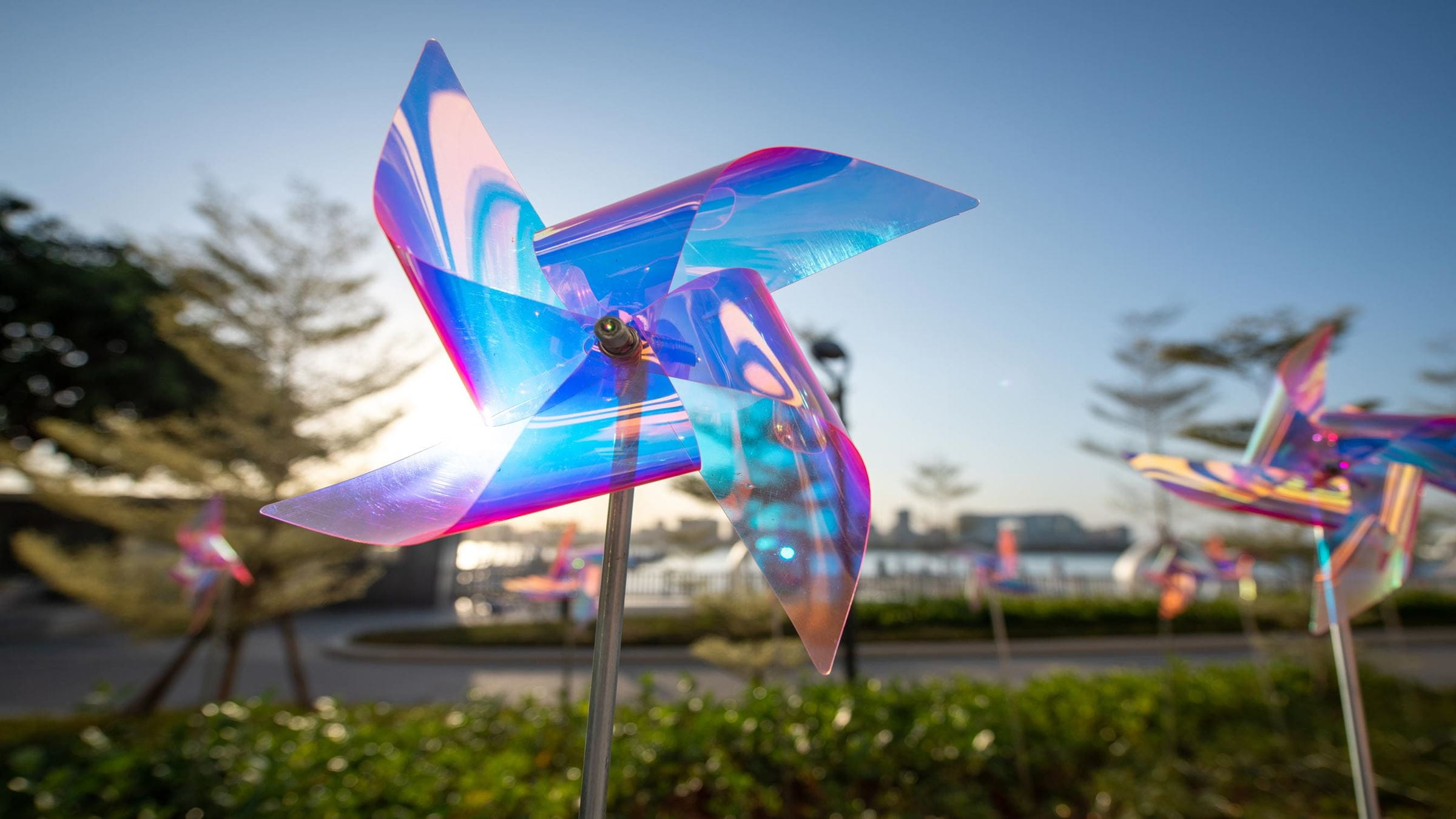 Plastic toy windmill in front of sun and sun light shining through the near transparent windmill