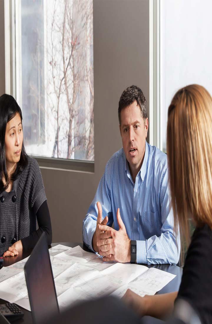 Business meeting with three people around a desk