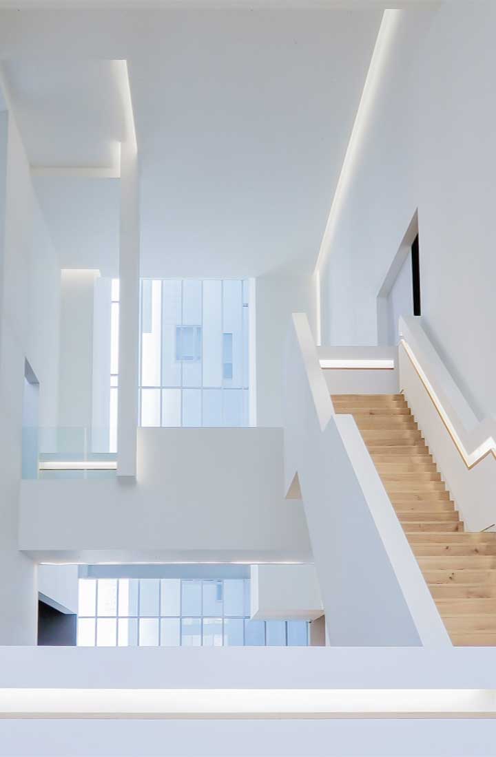 A white interior of a house with a staircase and a long window