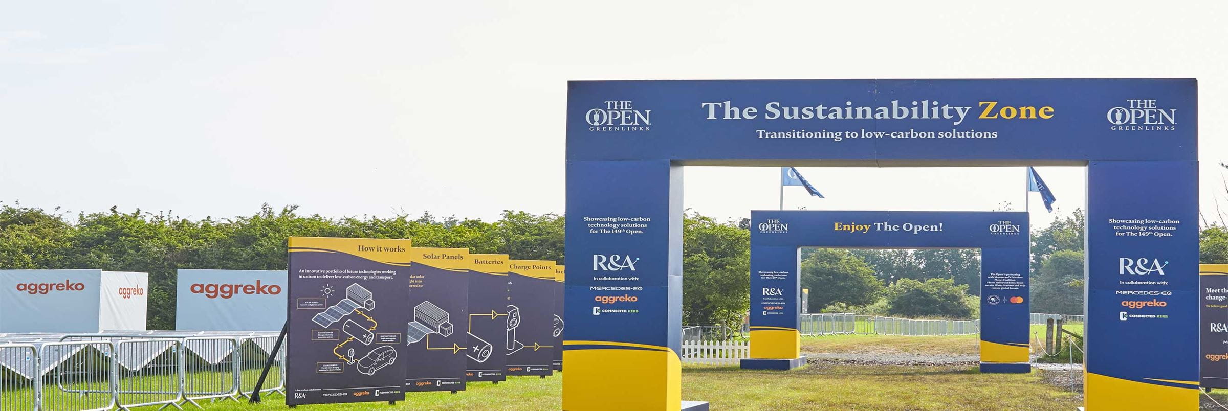 A man-made arch that indicates an entrance to The Open Golf championship, next to Aggreko power equipment